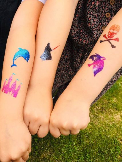 kids with glitter tattoos on arms
