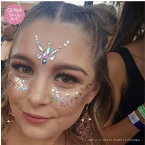 Girl wearing festival glitter and gems on her face at party
